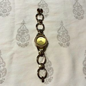A|X Armani Exchange gold bracelet-style watch with stones surrounding the dial.